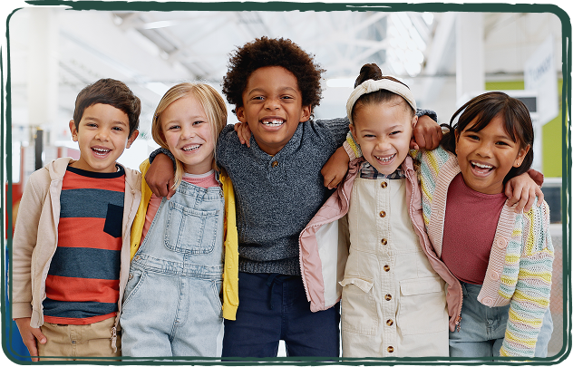Fünf Kinder stehen nebeneinander und lächeln in die Kamera